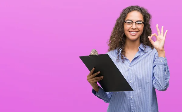 Joven Mujer Negocios Hispana Sosteniendo Portapapeles Haciendo Signo Con Los —  Fotos de Stock