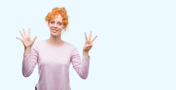 年轻的红头发的妇女显示和指着手指数八 而微笑的信心和快乐 — 图库照片