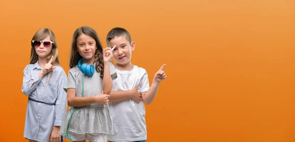 Group Boy Girls Kids Orange Background Very Happy Pointing Hand — Stock Photo, Image