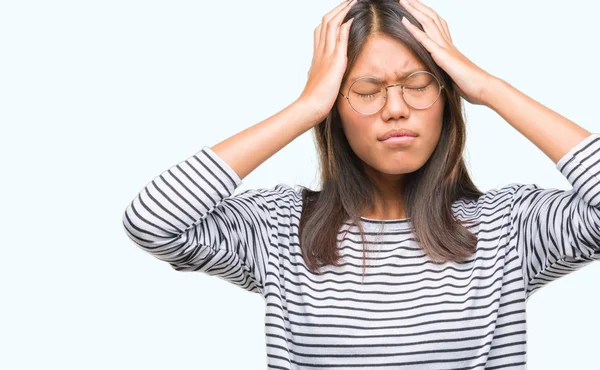 年轻的亚洲妇女戴眼镜在孤立的背景下患有头痛绝望和压力 因为疼痛和偏头痛 手在头上 — 图库照片