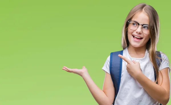 年轻漂亮聪明的学生女孩穿着背包在孤立的背景下惊讶和微笑的相机 而提出用手和手指指着 — 图库照片