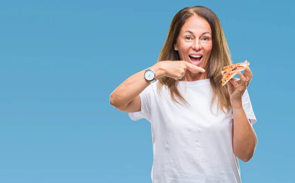 非常に幸せな手と指で指している分離の背景にピザのスライスを食べる中年ヒスパニック系女性 — ストック写真