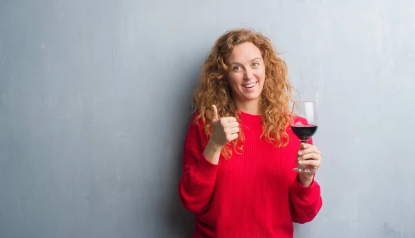 Joven Pelirroja Sobre Pared Gris Grunge Bebiendo Vaso Vino Feliz — Foto de Stock