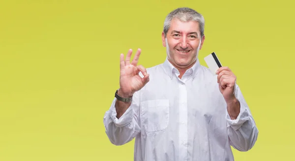 Bonito Homem Idoso Segurando Cartão Crédito Sobre Fundo Isolado Fazendo — Fotografia de Stock