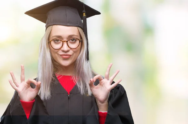 分離の背景の上の大学院の制服を着て若いブロンドの女性リラックスして瞑想の指ジェスチャーをやって閉じた目と笑顔します ヨガの概念 — ストック写真