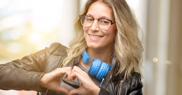 心臓形状表現健康と結婚のシンボルに手でヘッドフォン幸せを表示愛を持つ若い学生女性 — ストック写真