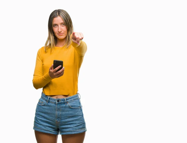 年轻美丽的女人发送消息使用智能手机在孤立的背景指向相机和你 正面和自信的手势从前面 — 图库照片