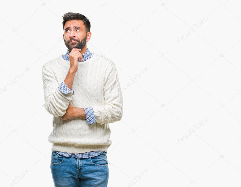 Adult hispanic man wearing winter sweater over isolated background with hand on chin thinking about question, pensive expression. Smiling with thoughtful face. Doubt concept.