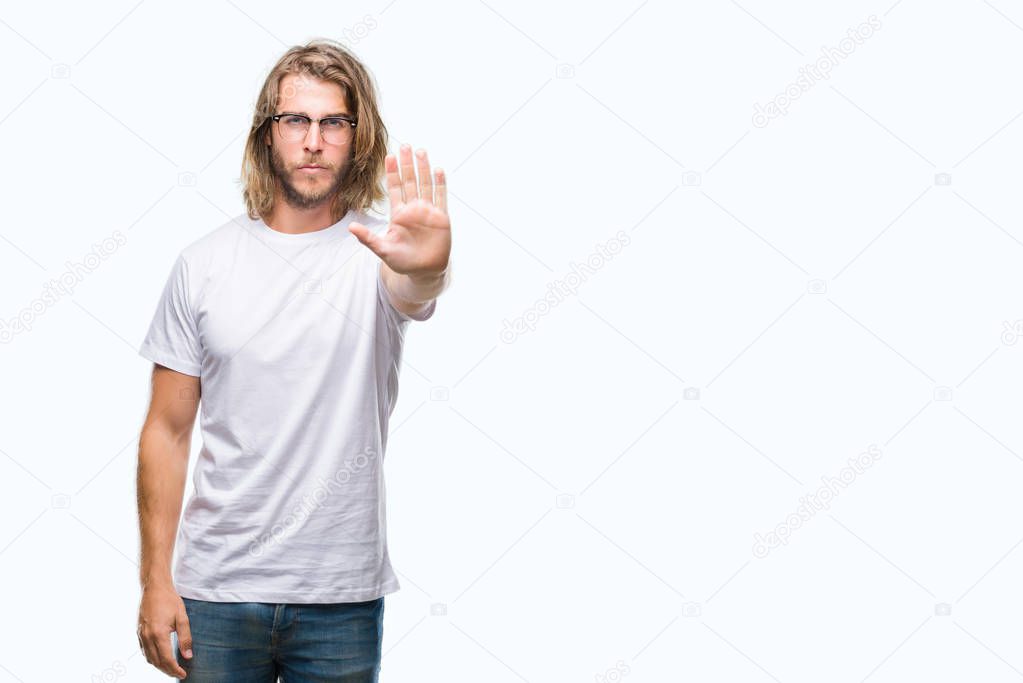 Young handsome man with long hair wearing glasses over isolated background doing stop sing with palm of the hand. Warning expression with negative and serious gesture on the face.