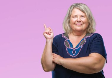 Kıdemli artı boyutu kameraya bakarak yan el ve parmak ile işaret yüzünde kocaman bir gülümseme ile arka plan üzerinde beyaz kadın izole.