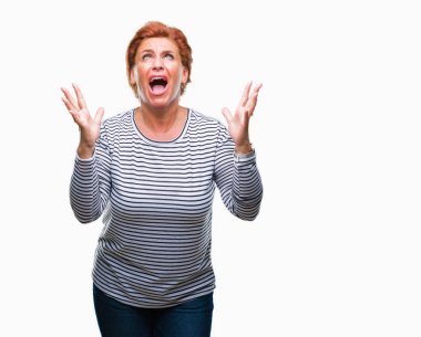 Atrractive üst düzey beyaz Kızıl saçlı kadın izole arka plan çılgın ve kızgın bağırarak ve agresif ifade ve silah kaldırdı bağırmaya. Hayal kırıklığı kavramı.