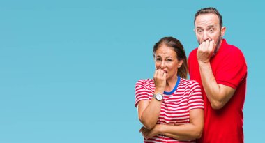 Orta yaş İspanyol çift stresli ve gergin elle çivi ısırma ağzına bakarak izole arka plan üzerinde aşık. Anksiyete sorunu.