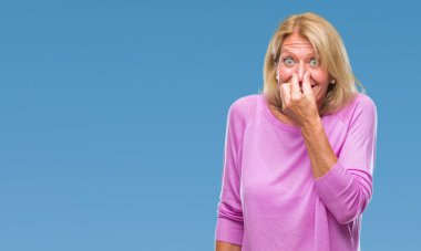 Bir şey pis ve iğrenç kokulu izole arka plan, dayanılmaz koku, holding nefes burun parmak ile orta yaş sarışın kadın. Kötü kokuyor kavramı.