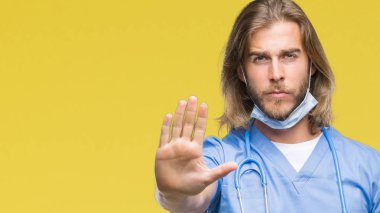 Genç yakışıklı adam uzun saçlı elin avuç durağı şarkı yapıyor izole arka plan üzerinde doktor. Negatif ve ciddi bir jest yüz ifadesiyle uyarı.