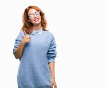 Genç güzel kadın hareketi el ile mutlu yaşasın yapıyor kış kazak giyen izole arka plan yüzünden. Kameraya bakarak başarı gösteren ile ifade onaylama.