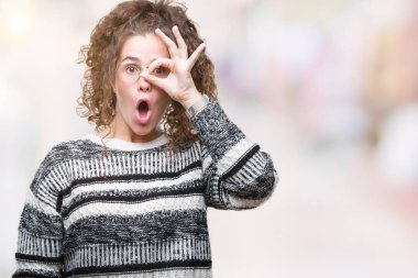 Güzel esmer kıvırcık saçlı Genç kız ok jest yapıyor izole arka plan üzerinde gözlük sürpriz yüz, göz parmaklarının arasından seyir ile şok. İmansız ifade.