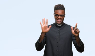 Gösterilen ve parmakları ile işaret izole arka plan genç Afro-Amerikan rahip adam kendinden emin ve mutlu gülümseyerek süre yedi numara.