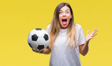 Futbol topu tutan genç güzel kadın büyük gülümseme ile çığlık zaferini kutluyor ve ellerini kaldırdı arka plan çok mutlu ve heyecanlı, kazanan ifade izole