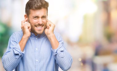 Yüksek sesle müzik gürültü rahatsız ifade parmaklarıyla kulaklarıyla kapsayan izole arka plan üzerinde genç yakışıklı adam. Sağır kavramı.