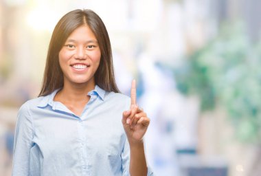 Genç Asyalı iş kadını ve parmak gülümseyen süre bir numara ile kendinden emin ve mutlu yukarıyı gösteren izole arka plan üzerinde.