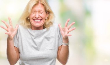 Orta yaş sarışın kadın deli ve silah ile başarı için deli kutluyor izole arka plan üzerinde kaldırdı ve heyecanlı çığlık gözler kapalı. Kazanan kavramı