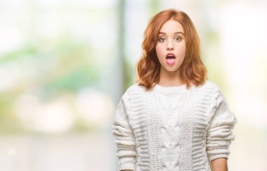 İzole arka plan kış kazak korkuyor ve şok sürpriz ifade, korku ve heyecan yüz ile giyen genç güzel kadın.