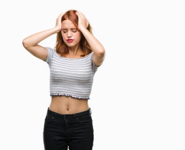 Genç ve güzel bir kadın, izole edilmiş arka planda acı ve migren yüzünden çaresiz ve stresli bir baş ağrısı çekiyor. Ellerini başının üstüne koy..