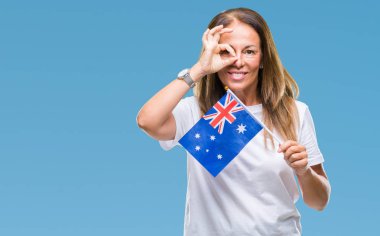 Avustralya bayrağı ile mutlu yüz el parmaklarının arasından seyir göz üzerinde ok işaretiyle yapıyor gülümseyen izole arka plan üzerinde tutan orta yaş İspanyol kadın