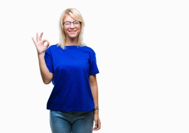 İzole arka plan el ve parmaklar ok işaretiyle yapıyor olumlu gülümseyen üzerinde gözlük takan genç güzel sarışın kadın. Başarılı ifade.