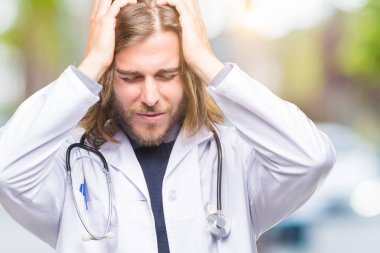 Genç yakışıklı Doktor uzun saçlı adam çünkü umutsuz ve stresli baş ağrısı acı izole arka plan üzerinde ağrı ve migren. Ellerini kafasına.