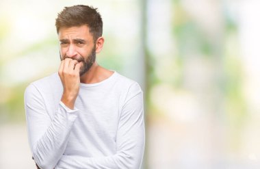 Yetişkin İspanyol adam stresli ve gergin ile izole arka plan üzerinde tırnak ısırma dudaklarından eller. Anksiyete sorunu.