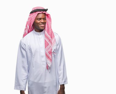 Geleneksel keffiyeh uzak tarafına yüzünde, doğal ifade gülümseme ile seyir izole arka plan üzerinde giyen genç Arapça Afrika adam. Kendine güvenen gülüyor.