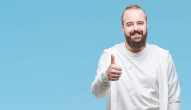 Genç beyaz hipster adam üzerinde spor kıyafetlerle hareketi el ile mutlu yaşasın yapıyor arka plan izole. Kameraya bakarak başarı gösteren ile ifade onaylama.
