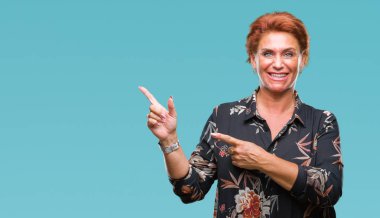 Atrractive üst düzey beyaz Kızıl saçlı kadın gülümseyerek ve iki elleri ve parmakları ile tarafına işaret kamera bakarak izole arka plan.