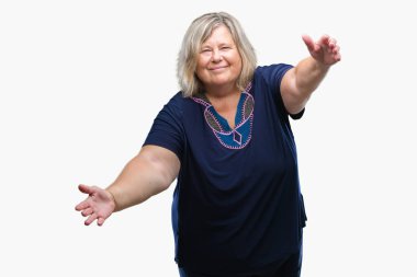 Kıdemli artı boyutu ile gülümseyerek kameraya bakarak arka plan üzerinde beyaz kadın izole silah sarılmak için açın. Neşeli ifade kucaklayan mutluluk.