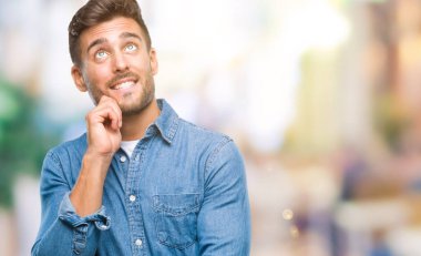 Yakışıklı delikanlı çene düşünme hakkında soru, dalgın ifade üzerine el ile izole arka plan üzerinde. Düşünceli yüzüyle gülümsüyor. Şüphe kavramı.