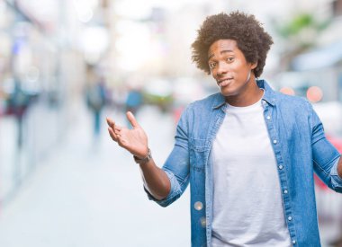 İzole arka plan clueless ve şaşkın bir ifadeyle kollar ve eller kaldırdı Afro Amerikan adam. Şüphe kavramı.