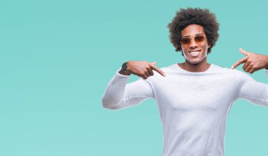 Yüzünde gülümseme ile kendinden emin görünüyorsun, kendini gururlu ve mutlu parmakları ile işaret izole arka plan üzerinde güneş gözlüğü takıyor Afro Amerikalı adam.