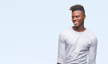 Afrikalı-Amerikalı genç uzak tarafına yüzünde, doğal ifade gülümseme ile seyir izole arka plan üzerinde. Kendine güvenen gülüyor.