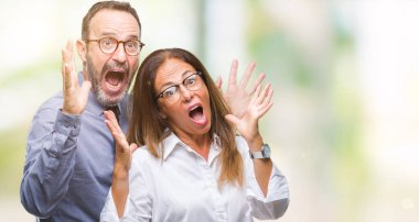 Orta yaş İspanyol çift üzerinde gözlük takan aşık deli ve çığlık kaldırdı ve açık gözleri heyecanlı silah ile başarı için hayran kutluyor arka plan izole. Kazanan kavramı