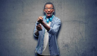 Afrika siyah adam öğrenci smartphone ile rahatsız ve kızgın negatif duygu ifade, birisi ile rahatsız