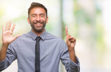 Yetişkin İspanyol iş adamı gösterilen ve parmakları ile işaret izole arka plan üzerinde kendinden emin ve mutlu gülümseyerek süre 6 numara.
