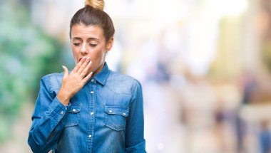 Genç güzel kadın izole arka plan üzerinde el ile ağız kapsayan yorgun esneme sıkılmış. Restless ve uyku hali.