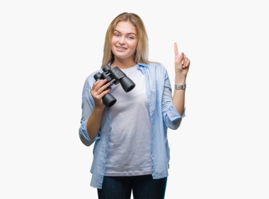 Genç kafkas kadın holding dürbün üzerinden arka plan ile bir fikir ya da gülen yüz, bir numara ile parmak işaret soru sürpriz izole