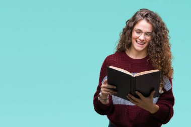 Genç esmer kız gözlüklü izole arka plan üzerinde duran ve diş gösterilen kendine güvenen bir gülümsemeyle gülümseyerek mutlu bir yüz ile bir kitap okuma