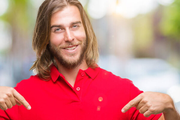 Young handsome man with long hair over isolated background looking confident with smile on face, pointing oneself with fingers proud and happy.