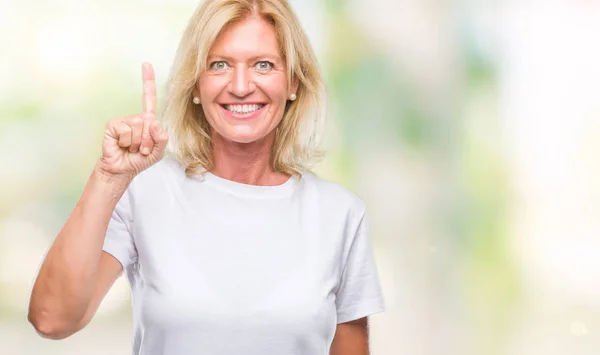 中年金发女人在孤立的背景显示 并指出手指第一 而微笑着自信和快乐 — 图库照片