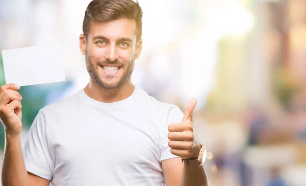 Jovem Homem Bonito Segurando Cartão Branco Sobre Fundo Isolado Feliz — Fotografia de Stock