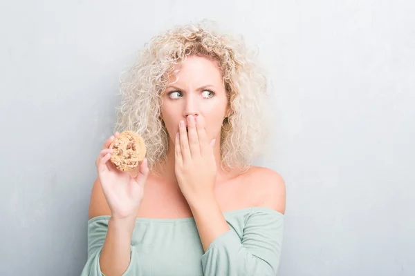 Joven Mujer Rubia Sobre Pared Gris Grunge Comer Chocolate Chip —  Fotos de Stock