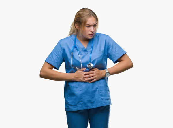 年轻的白种医生妇女穿着外科医生制服在孤立的背景与手在胃部由于消化不良 痛苦的病症感觉不适 Ache — 图库照片